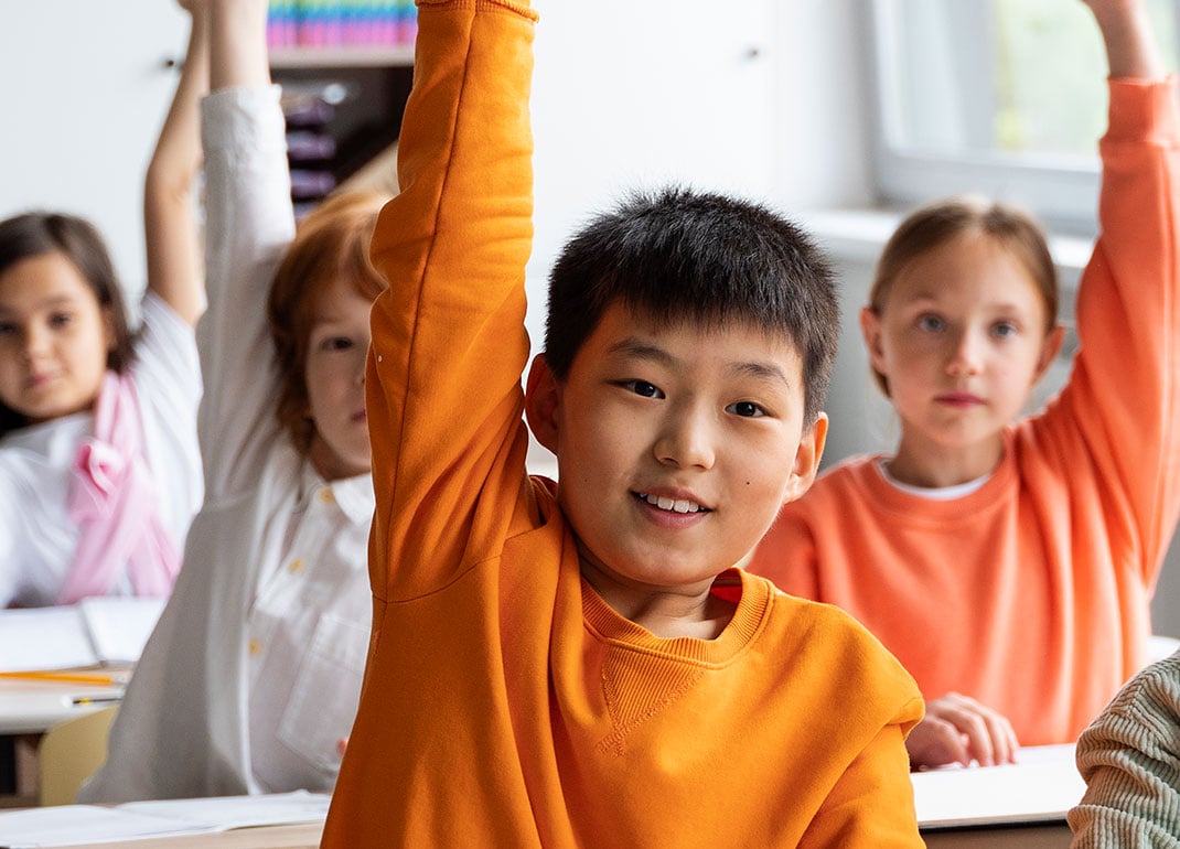 kids-raising-hands-in-class